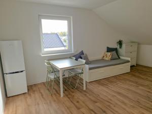 Habitación con sofá, mesa y ventana en Apartament Nadwarciański, en Śrem