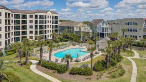 an aerial view of a resort with a pool and palm trees at 402 Summerhouse by AvantStay Beachfront Condo w Community Pool Access in Isle of Palms