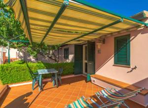 un patio con toldo, mesa y sillas en Caserta Holiday Rent, en Ustica