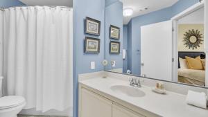 a bathroom with a sink and a toilet and a mirror at 402 Summerhouse by AvantStay Beachfront Condo w Community Pool Access in Isle of Palms +44 photos