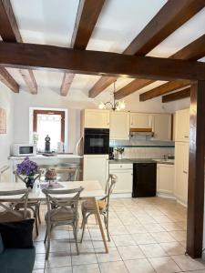 a kitchen and dining room with a table and chairs at Relais du Dompeter in Molsheim
