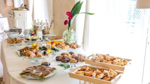 a table filled with different types of bread and pastries at Hotel Villa Bernt in Grado