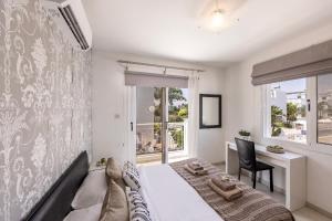 a bedroom with a bed and a desk and a window at Nissini villa in Ayia Napa
