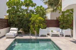 a patio with a pool and chairs and trees at Nissini villa in Ayia Napa