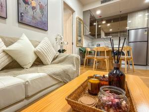 a living room with a couch and a table at Luxury Downtown Bangkok 2BR 2BA Sky Pool Gym 5MIN Walk to Siam Paragon in Pratunam