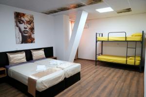 a room with a bed and two bunk beds at Хостел Цанови in Pleven