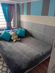 a teddy bear sitting on a bed in a bedroom at Domek Agroturystyczny Doris in Stężyca +9 photos