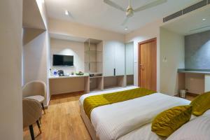 Un dormitorio con una cama grande y una cocina. en M Suites And Hotel, en Kochi