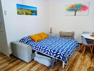 a bedroom with a bed with a blue and white comforter at La Casita de Ale Casa Rural cerca Puy du Fou in Polán +13 photos