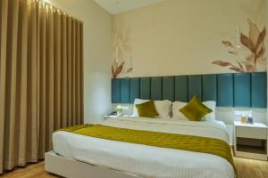 Un dormitorio con una cama grande con cabecero azul. en M Suites And Hotel, en Kochi