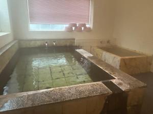 a bathroom with a bath tub and a sink at 北海道ゲストハウス川湯温泉6丁目 in Kawayu +71 photos