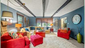a living room with a couch and chairs and a clock at Double Diamond Lodge by AvantStay Group Escape w Firepit Patio Activities in Lake Harmony