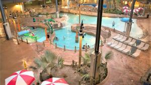 an indoor water park with a pool with people in it at Double Diamond Lodge by AvantStay Group Escape w Firepit Patio Activities in Lake Harmony