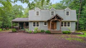 a gray house with a gambrel roof and a porch at Double Diamond Lodge by AvantStay Group Escape w Firepit Patio Activities in Lake Harmony