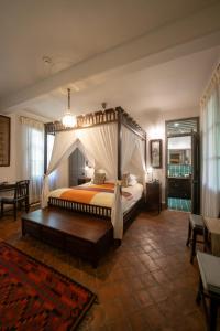 a bedroom with a canopy bed in a room at Satri House Hotel in Luang Prabang +54 photos