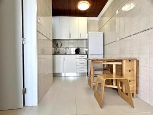 a kitchen with a wooden table and a refrigerator at Countryside Home by Trip2Portugal in Sobral da Abelheira
