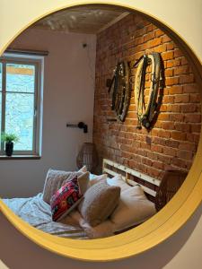 a bed in a room with a brick wall at Villa Pippi in Tokarnia