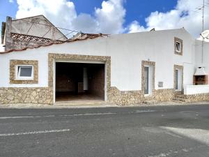 a white building with an open garage at Countryside Home by Trip2Portugal in Sobral da Abelheira