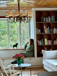 a woman sitting in a window sill looking out the window at Villa Pippi in Tokarnia +117 photos