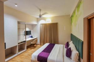 una habitación de hotel con una cama y un escritorio en M Suites And Hotel, en Kochi