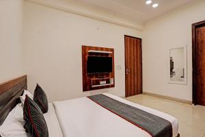 a bedroom with a bed with a television in it at Hotel O Golden Palace in Noida