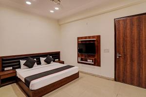 a bedroom with a large bed and a television at Hotel O Golden Palace in Noida