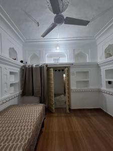 プシュカルにあるGanpati homestayの天井ファンとベッドが備わる客室です。 +7枚の写真