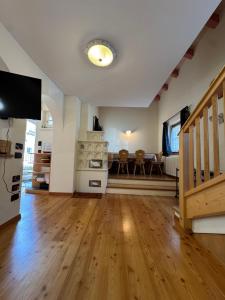 a living room with a wooden floor and a tv at Cèsa Emily in Campitello di Fassa
