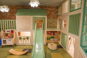 une maison de poupée avec un toboggan au milieu dans l'établissement BalticTime - domki z jacuzzi i saunami, à Ostrowo