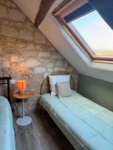 a bedroom with a bed in a attic with a skylight at Domaine de La Nouillière - Jacuzzi in Saint-Nicolas-de-Bourgueil