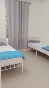 a bedroom with two beds and a curtain at Homestay Bajet Kg Telaga Mas Paka in Paka