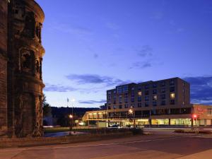 a building on the side of a street at night at Mercure Hotel Trier Porta Nigra in Trier