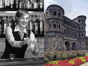 a woman standing at a bar with a drink in front of a building at Mercure Hotel Trier Porta Nigra in Trier