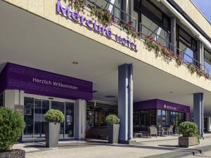 a hospital building with potted plants in front of it at Mercure Hotel Trier Porta Nigra in Trier