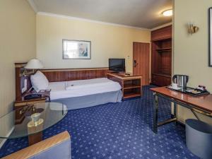 a hotel room with a bed and a television at Mercure Hotel Trier Porta Nigra in Trier