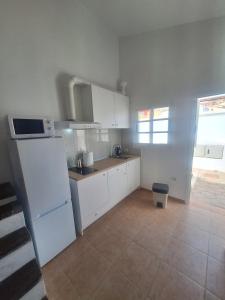 a kitchen with white cabinets and a tile floor at Casa vista golf in Caleta De Fuste