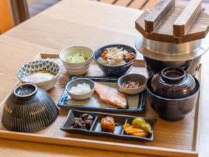 ein Tablett mit Sushi und anderen Gerichten auf einem Tisch in der Unterkunft TimeResort Kakureya - Vacation STAY 36094v in Inashiki