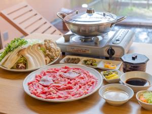 einen Tisch mit Tellern und einer Kanne Essen in der Unterkunft TimeResort Kakureya - Vacation STAY 36094v in Inashiki