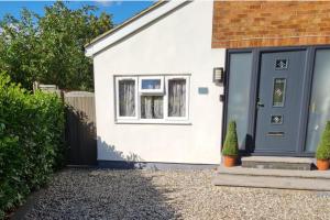 a white house with a blue door at 1 Bed Sleeps 2 with Private Garden in Harlow