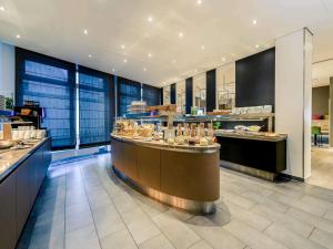 a restaurant with a counter with food on it at Mercure Hotel Hannover Mitte in Hannover