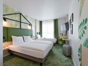 a hotel room with two beds and a desk at Mercure Hotel Hannover Mitte in Hannover +221 photos