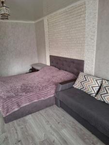a bedroom with two beds and a brick wall at Апартаменти проспект Богоявленський 20 біля Автовокзалу in Mykolaiv