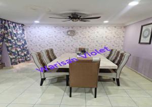 a dining room with a table and chairs and a ceiling at Homestay Warisan Violet Bertam Jaya in Melaka
