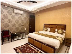 a bedroom with a bed and a chair and a desk at Hotel AV Ganges Varanasi - Walking Distance From BABA VISHWANATH TEMPLE #Wifi #Fully Air Conditioned & Spacious Rooms - Best Budget Hotel In Varanasi in Varanasi +16 photos