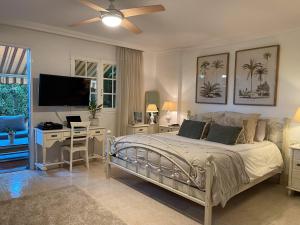 ein Schlafzimmer mit einem Bett, einem Schreibtisch und einem Fernseher in der Unterkunft Preciosa Casa Con Jardín Privado in Puerto de la Cruz + 37 Fotos