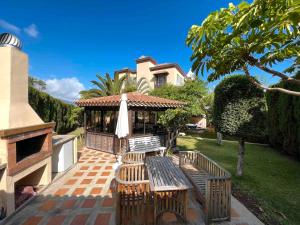 eine Terrasse mit Tisch und Stühlen vor einem Haus in der Unterkunft Preciosa Casa Con Jardín Privado in Puerto de la Cruz