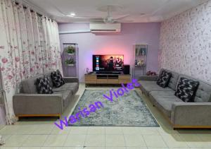 a living room with two couches and a tv at Homestay Warisan Violet Bertam Jaya in Melaka