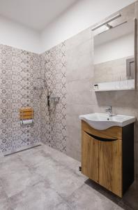 a bathroom with a sink and a mirror at STADIUM HOME Panzió in Németbarnag +30 photos