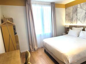 a hotel room with a bed and a window at Mercure Lourdes Impérial in Lourdes