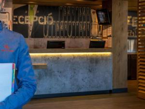 a man standing in front of a counter in a store at Ibis Budget Barcelona Viladecans in Viladecáns +30 photos